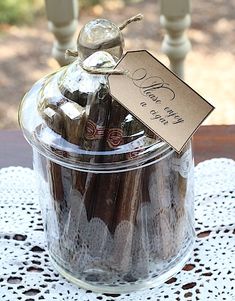 a jar filled with chocolate covered strawberries sitting on top of a doily table