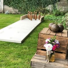 a vase with flowers sitting on top of a wooden crate