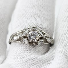 a diamond ring sitting on top of a white cloth