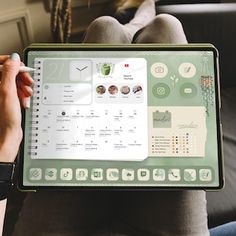 a person sitting on a couch holding up a laptop computer with the screen showing icons