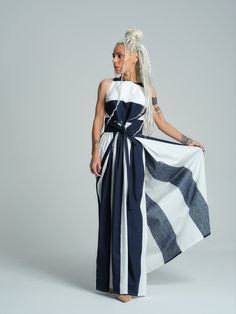 The iconic navy and white color palette and gorgeous waist-cinching silhouette make this dress the perfect vacation statement piece. Allow the stunning pattern to take center stage by pairing it with classic nude pumps. FEATURES:A printed maxi dress with a wrap cut and a tie at the waist. Please note that this piece does not feature pockets.100% Handmade. SIZE & FIT:Fit: Slim fit bodice, relaxed skirtThe model is wearing size Small or S/MView our SIZE CHART before ordering MATERIALS & CARE:Content: 50% Cotton, 50% PolyesterCare: Machine wash on cold (30ºC) with a mild detergent. SHIPPING:Made to order, the processing time is 15 working daysThis item will be shipped via DHL Luxury Abstract Print Maxi Dress, Chic Striped A-line Maxi Dress, White Color Palette, Striped Beach Maxi Dress, Lined, Elegant Maxi Dress With Abstract Print And V-neck, V-neck Beach Dress With Abstract Print, Nude Pumps, Border Print, Cinched Waist