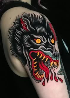 a man with a tattoo on his arm that has a wolf head and flames coming out of it