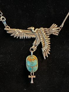 a necklace with an eagle and cross on it