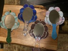 three flower shaped mirrors sitting on top of a wooden table