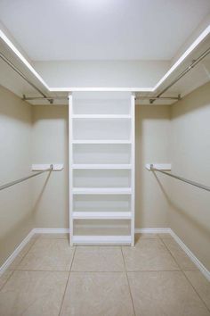 an empty walk in closet with white shelves