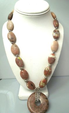 For sale: (1) s108 Genuine Rhodonite Necklace Sterling Silver Lock Donut Pendant Necklace 24"   PLEASE READ ENTIRE DESCRIPTION BEFORE PURCHASING   Pre-owned item. Good condition.    An eye catching necklace which will look fabulous among ladies of all age group.  This gorgeous rhodonite necklace has some beautiful shades of pink, brown, black & grey. I just love the uniqueness of rhodonite with it's beautiful striations. This necklace measures approx. 24" in length , and the extender  is another 3" in length.  The donut is large at 2" round.  Between each gemstone are 6mm sterling silver balls. Sterling silver lobster claw closure    *This picture displays the exact item that you will receive. We do our best to show everything in the pictures.   -------------------------------------------- Oval Hand-strung Jewelry As A Gift, Round Jasper Jewelry For Healing, Handmade Oval Jasper Necklaces, Round Jasper Healing Jewelry, Handmade Oval Jasper Necklace, Handmade Jasper Oval Necklaces, Handmade Jasper Oval Necklace, Donut Necklace Gemstones, Hand-strung Jasper Necklaces As A Gift