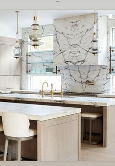 an image of a kitchen setting with marble counter tops and stools in the center