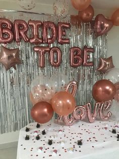 the bride to be balloon arch is decorated with rose gold balloons and confetti