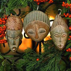 two masks are hanging on a wreath with berries