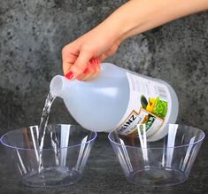 someone pours water into small cups on a table