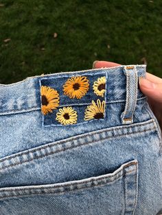 someone is showing off their jeans with sunflowers on the back pocket and side pockets