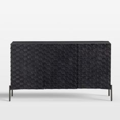 the sideboard is made out of black plastic and has an unusual pattern on it