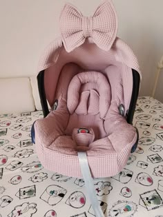 a pink baby seat with a bow on it