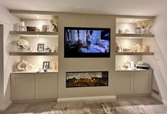 a flat screen tv mounted to the side of a wall next to a fire place