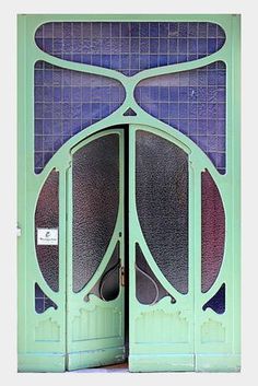 an open green door with blue tiles on it