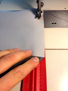 a person is using a sewing machine to sew on some material with their hands