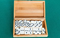 a wooden box filled with dices on top of a green floor