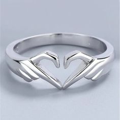 a white gold ring with two hands in the shape of a heart, on a gray background