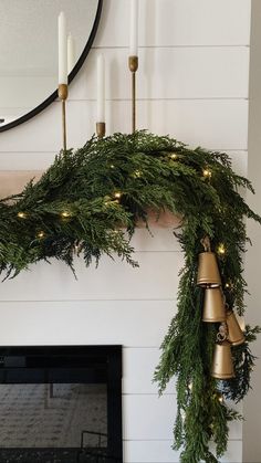 a christmas garland with bells hanging from it's side next to a fire place