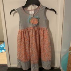 Adorable Little Girl Dress Size 6. Gray Top And Bottom With A Peach Stitching Around The Neck And Hem Line. Peach Background With Blue And White Flowers With Green Leaves. Pretty Peach Flower Attached To The Front Chest With Sparkly Center. Never Worn. Playful Orange Sleeveless Dress, Playful Orange Dress For Spring, Playful Orange Spring Dress, Orange Sleeveless Dress For Playtime, Casual Orange Playtime Dress, Casual Orange Dresses For Playtime, Casual Orange Dress For Playtime, Orange Cotton Playtime Dress, Playful Orange Cotton Dress