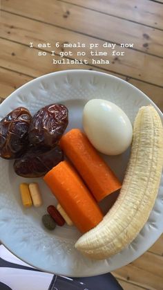 a white plate topped with carrots, an egg and other foods on top of it