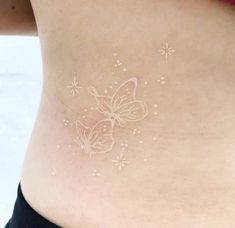 a woman's stomach with white butterflies on it and stars all over the side