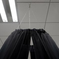 the curtain is hanging down from the ceiling with chains attached to it's sides