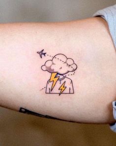 a woman's arm with a lightning and cloud tattoo on it