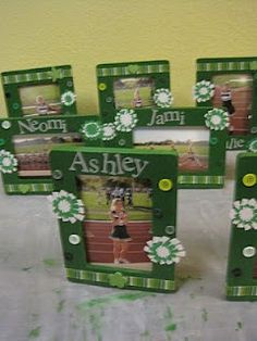 four green frames with flowers and the word ashley on them are sitting on a bed