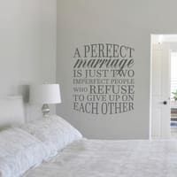 a bedroom with a bed and a wall decal that says a perfect marriage is just two imperfect people who refuse to give up on each other