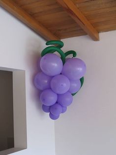 a bunch of purple balloons hanging from the side of a wall next to a mirror