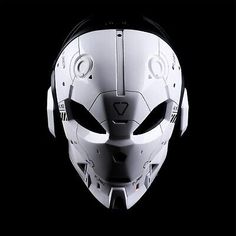 a white mask with black eyes and headphones on top of a black background in the shape of a helmet