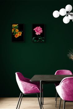 a dining room with green walls and pink chairs in front of a table that has flowers on it