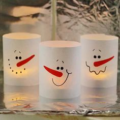 three frosty cups with faces drawn on them sitting on a counter next to a mirror