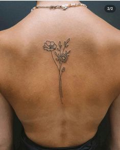 the back of a woman's neck with flowers tattooed on her left shoulder and lower back