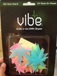 someone is holding up some fake flowers in their hand and it says vibe glow in the dark shapes