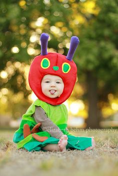 a baby sitting on the ground wearing a costume