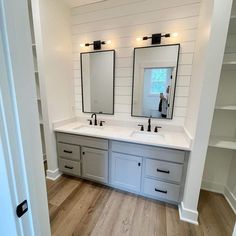 a bathroom with double sinks and two mirrors on the opposite side of the sink area