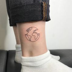 a small earth tattoo on the ankle