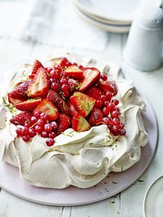 a white cake with strawberries and berries on top