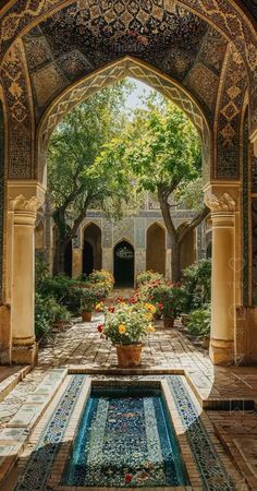 an archway leading into a garden with flowers and potted plants on the ground in front of