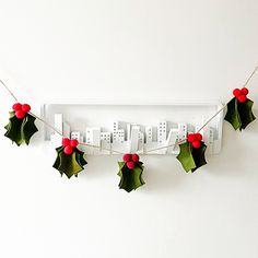 a white shelf with holly decorations hanging from it's sides