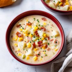 two red bowls filled with corn and cheese soup