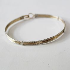 "A terrific little bracelet of six strands of wire--two plain 14kt gold filled wires on the inside, flanked by four sterling silver twist wires on the outside. Charming, comfortable, and feminine, and two-tone is really \"in\" right now! The sturdy built-in hook and eye clasp is easy to get on and off by yourself. This bracelet can also be made in all 14kt gold filled or all sterling silver. They would look AMAZING all three stacked together! Choose your size from the variations listed for a cus Delicate Adjustable Jewelry With Bracelet Strap, Gold Adjustable Double Band Bracelet, Adjustable Double Band Gold Bracelets, Adjustable Double Band Gold Bracelet, Adjustable Double Band Gold Bangle, Gold Double Band Adjustable Bracelets, Gold Multi-strand Wrap Bracelet For Gift, Gold Wrap Bracelet For Layering, Silver Multi-strand Hand Wrapped Bracelets