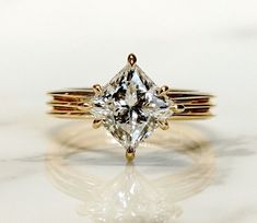 a close up of a diamond ring on a white surface