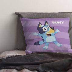 a pillow that is on top of a bed with a cartoon dog on it's side