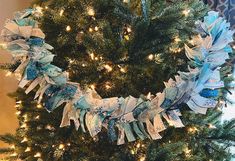 a christmas tree decorated with blue and white ribbons