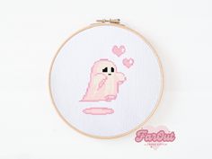 a cross stitch pattern with a pink dog on it's face and hearts in the background