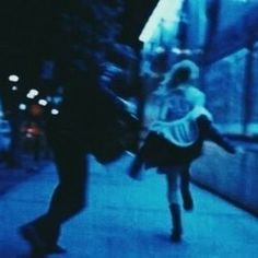 two people walking down the street at night