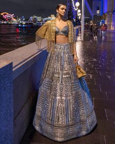 This lehenga set features antique silver sequin embroidery in a geometric pattern. The blouse shows crystal tassels at the waist. Embroidered dupatta also shows crystal tassels. The outfit can be paired with (an optional) antique gold cape jacket with matching embroidery. The jacket has heavy beaded tassels.From Seema Gujral's For the love of London collection. DELIVERY TIMEPlease allow 8-12 weeks for your outfit to arrive. FABRIC DETAILSNet Professional cleaning only. Cape Lehenga, Sequin Lehenga, Jacket Lehenga, Seema Gujral, Matching Embroidery, Tassel Jacket, Kurta Lehenga, Lehenga Pattern, Sequin Cape